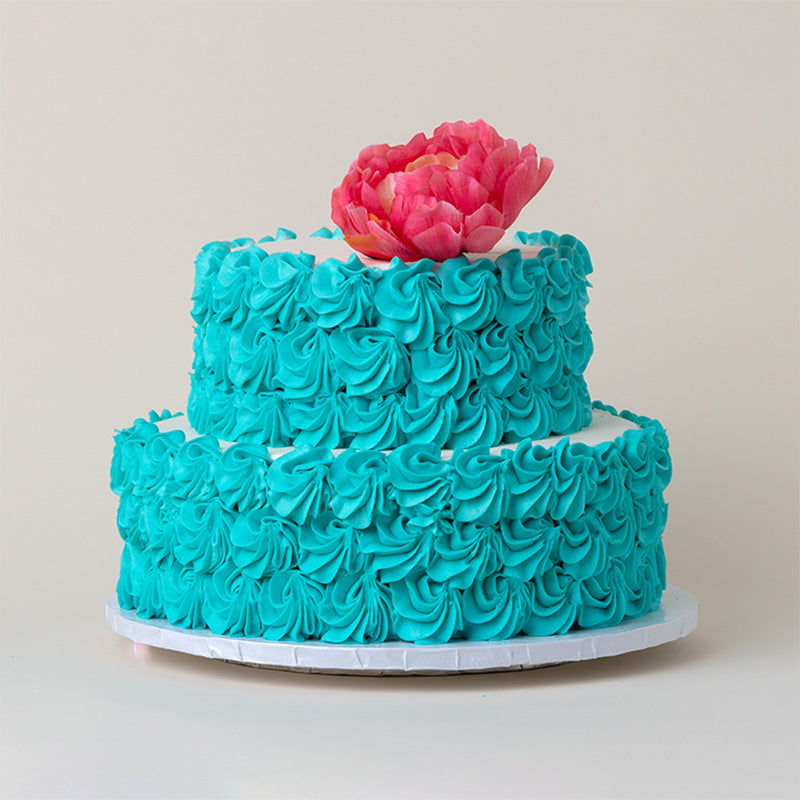 Cake with blue frosting and flower on top
